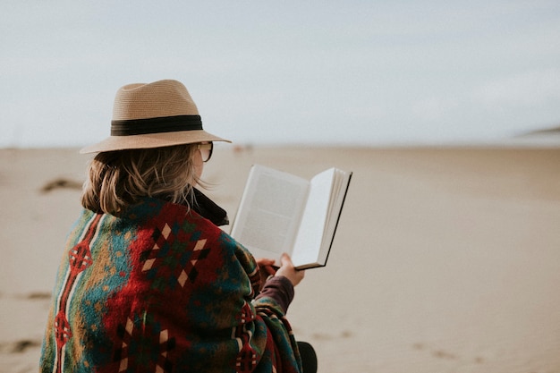 Photo femme âgée profitant de son livre en vacances