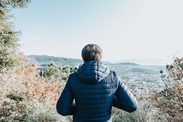 Femme âgée en randonnée dans la forêt. Personnes actives à l'extérieur. Paysage paisible et pittoresque. S'amuser pendant la journée de trekking dans les bois Concept de voyage. Nouvelles habitudes saines. Espace de copie. Femme active par temps froid