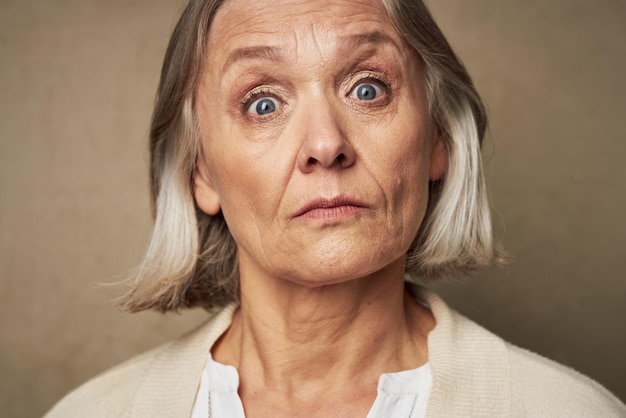 Femme âgée en robe visage gros plan posant fond isolé