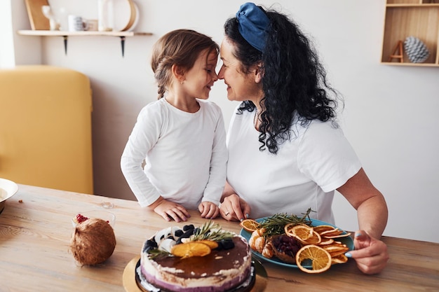 Femme âgée avec sa petite-fille préparant un gâteau diététique dans la cuisine