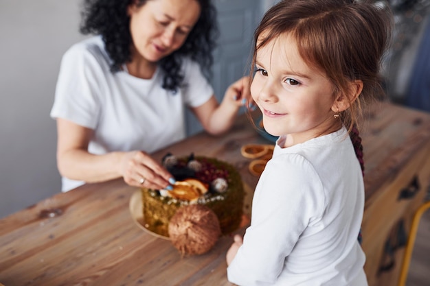 Femme âgée avec sa petite-fille préparant un gâteau diététique dans la cuisine