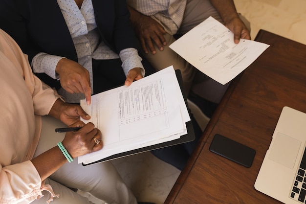 Une femme âgée signe un contrat immobilier avec un agent immobilier