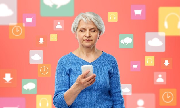 Photo femme âgée avec un smartphone sur des icônes d'applications mobiles