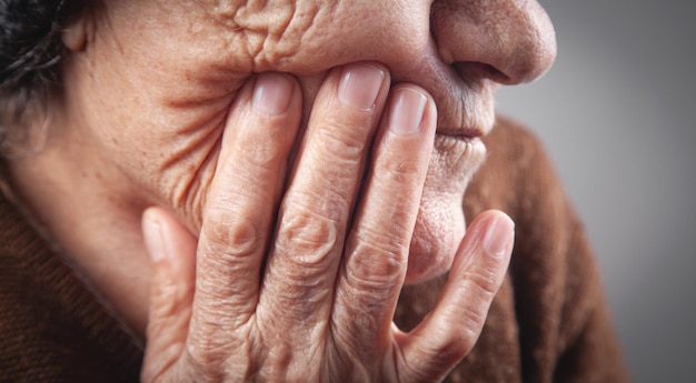 Femme âgée souffrant de douleurs dentaires