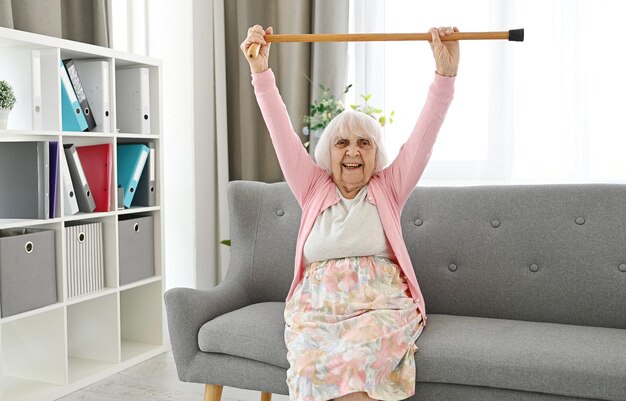Une femme âgée soulève une canne pour marcher vers le haut, symbolisant la victoire sur la maladie.