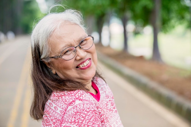 Une femme âgée souriant à la caméra.