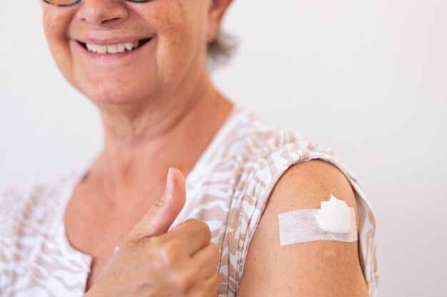 Femme âgée souriante des années 70 après avoir reçu le vaccin contre le coronavirus covid-19.