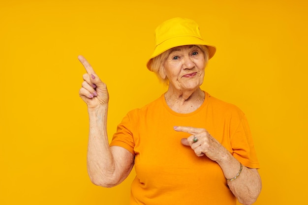 Femme âgée en t-shirt décontracté panama jaune fond isolé