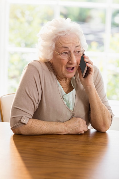 Femme âgée téléphonant à la maison