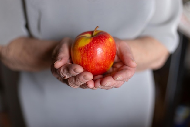 femme âgée tenant une pomme