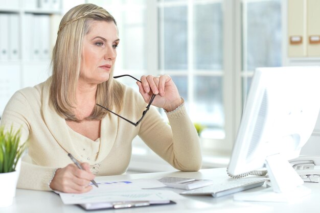 Femme âgée travaillant au bureau