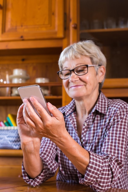 Femme âgée utilisant un téléphone faisant un appel vidéo