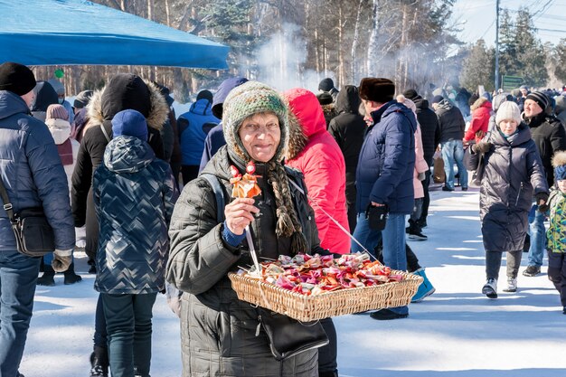 Une femme âgée vend des souvenirs faits à la main au festival Maslenitsa