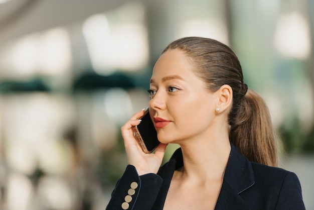 Une femme agent immobilier dans un blazer travaille à la table dans le hall moderne