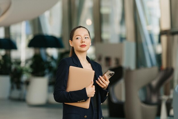 Une femme agent immobilier dans un blazer travaille à la table dans le hall moderne