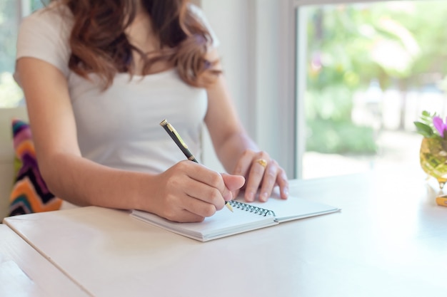 femme à l&#39;aide de la calculatrice et prendre note calculer sur le coût à la maison.