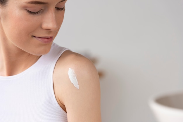 Photo femme à l'aide d'une crème de soin de la peau