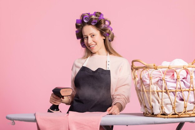 Une femme à l'aide d'un fer à repasser à vapeur pour repasser une chemise ordinaire à la maison girl making steam jet iron to iron clothes