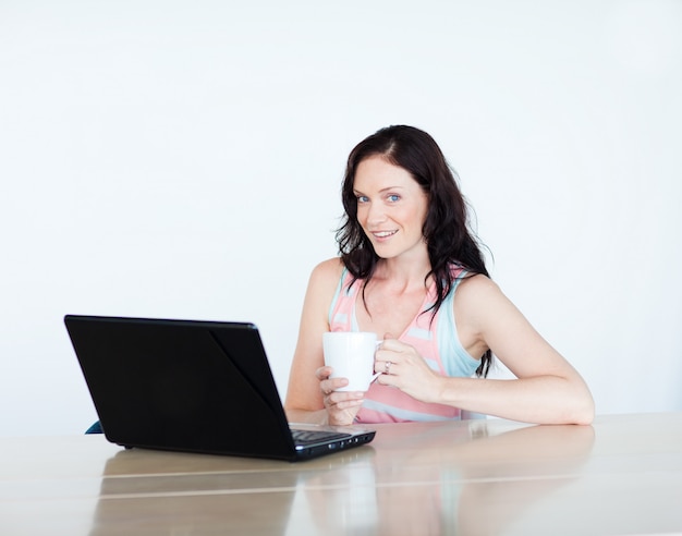 Femme à l&#39;aide d&#39;un ordinateur portable et de boire du café