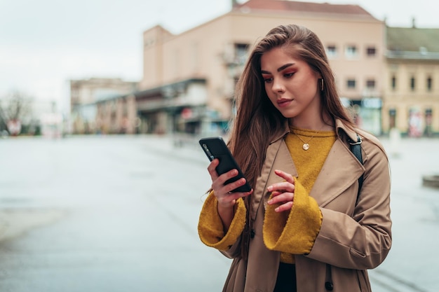 Femme à l'aide d'un smartphone à l'extérieur