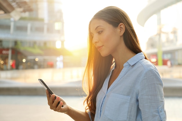 Femme à l'aide de son smartphone à l'extérieur