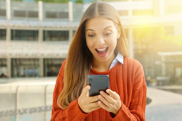 Femme à l'aide de son smartphone à l'extérieur