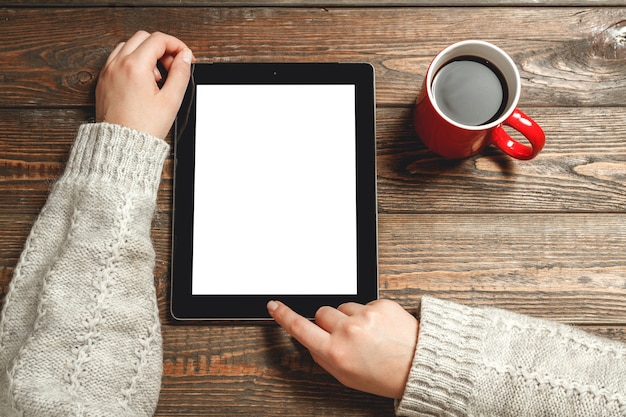 Femme à l'aide de tablette et café à la main