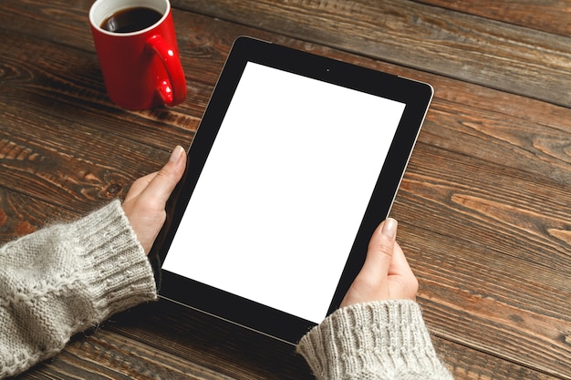 Femme à l'aide de tablette et café à la main