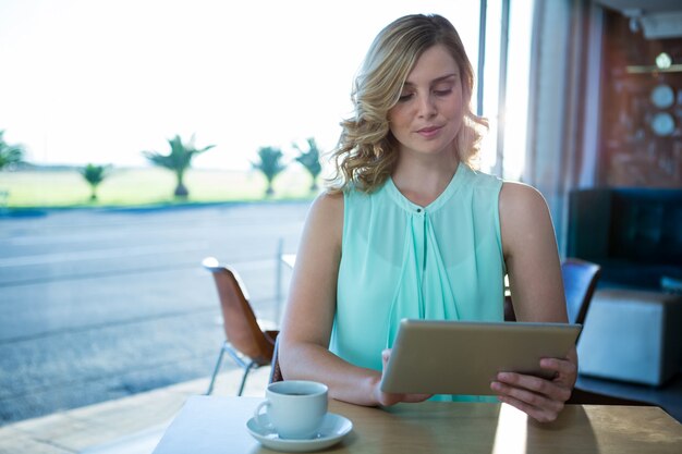 Femme à l'aide d'une tablette numérique dans le café