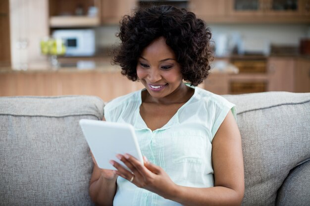 Femme à l'aide de tablette numérique dans le salon