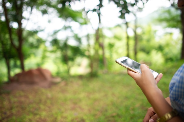 Femme à l'aide de téléphone dans la forêt