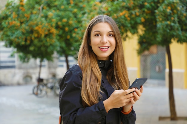 Femme à l'aide d'un téléphone mobile dans la rue de la ville