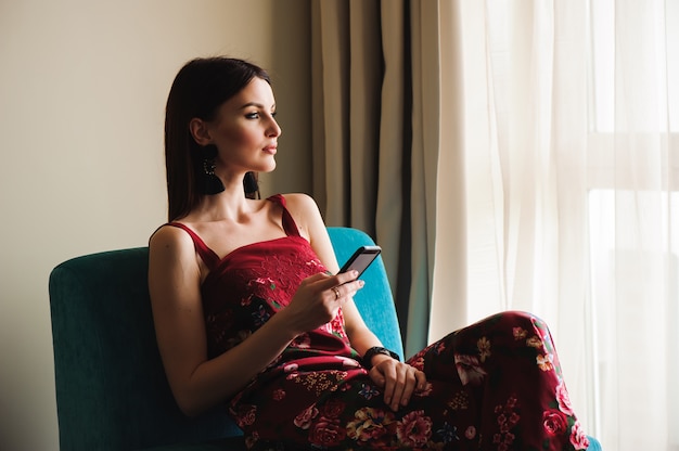 Femme à l'aide d'un téléphone portable sur un canapé.