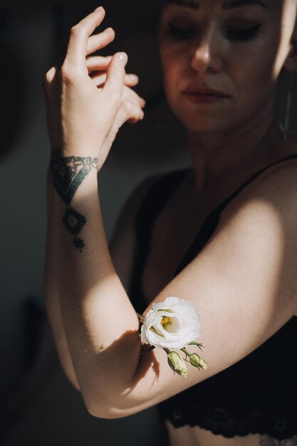 Femme aimante avec une fleur blanche sur son corps Gros plan d'une main féminine dans la lumière du soleil