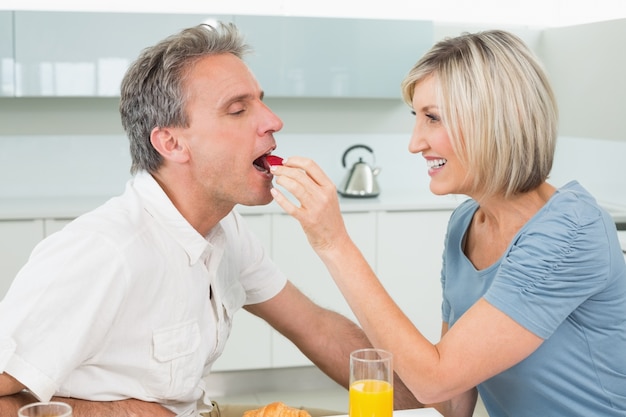 Photo femme aimante nourrir l'homme dans la cuisine
