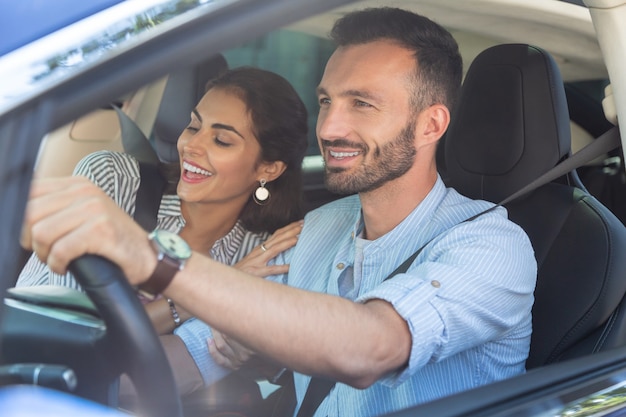 Femme Aimante S'embrassant. Femme Souriante Aimante étreignant Son Beau Mari Barbu Au Volant D'une Voiture