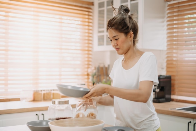 La femme aime cuisiner des nouilles simples dans la cuisine comme un passe-temps