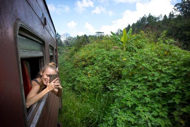 Une femme aime voyager dans la nature dans un train au Sri Lanka