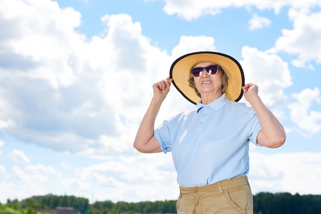 Femme aînée, à, a, chapeau, et, lunettes soleil