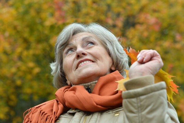 Femme aînée marchant dans le parc en automne