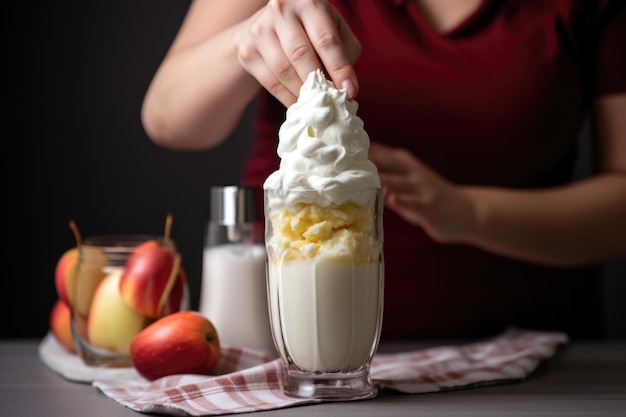 Photo une femme ajoutant de la crème fouettée sur un shake de tarte aux pommes