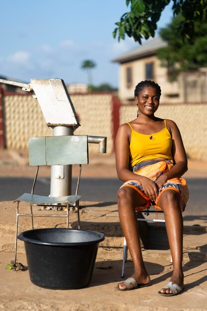 Femme allant chercher de l'eau à l'extérieur