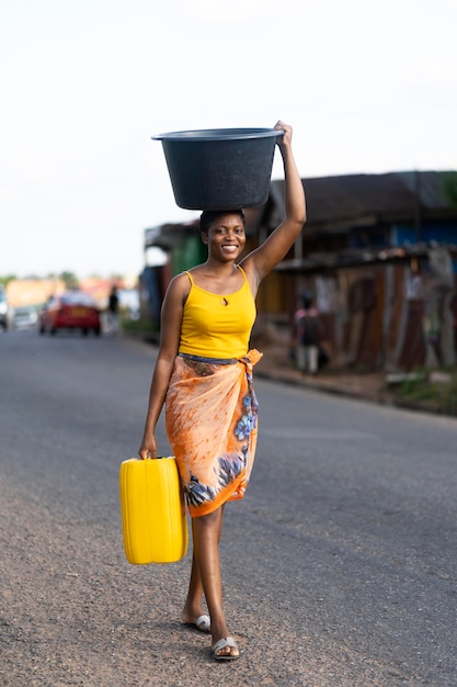 Femme allant chercher de l'eau à l'extérieur