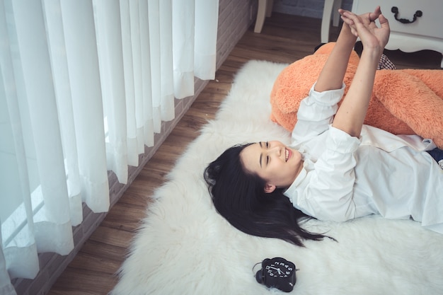 Une femme allongée au bout du lit sous la couette