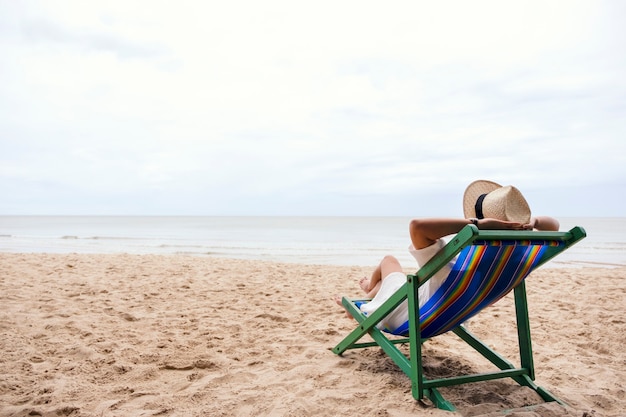 Une femme allongée sur une chaise de plage avec un sentiment de détente