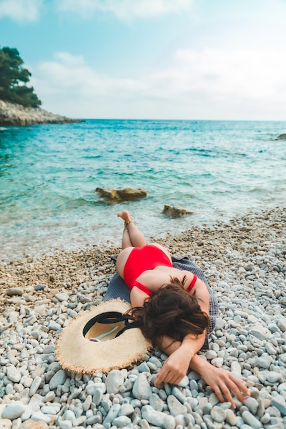 Femme allongée sur une couverture en mer plage copie espace