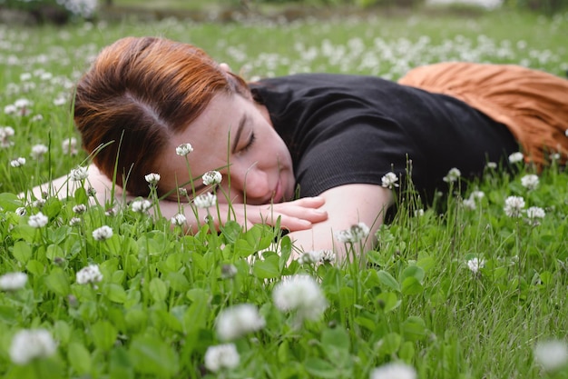 Une femme allongée dans l'herbe souriante