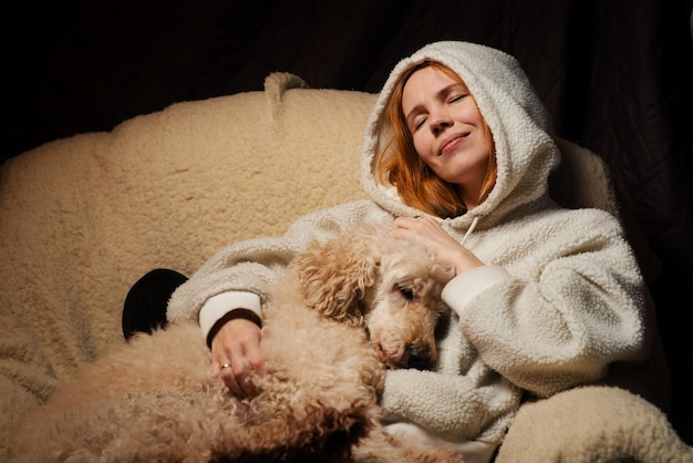 Femme allongée avec un gros chien sur le canapé Le chien domestique poilu a posé sa tête La relation entre les animaux et les personnes à la maison