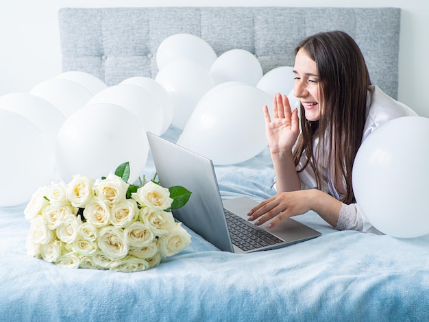 Femme allongée sur le lit avec des décorations avec des ballons pour la fête d'anniversaire