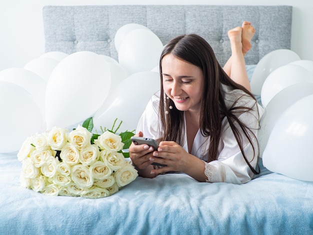 Femme allongée sur le lit avec des décorations avec des ballons pour la fête d'anniversaire